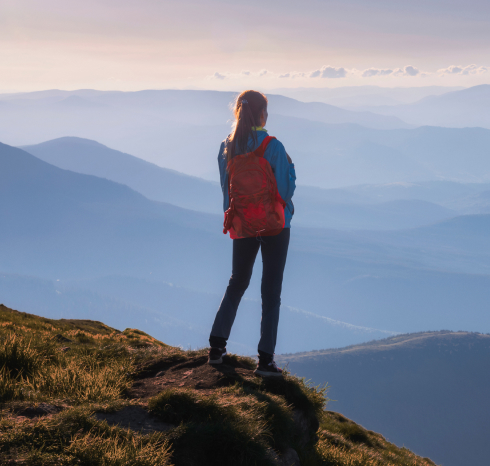 Mujer en la cima de una montaña, admirando el paisaje